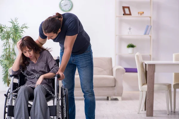 Gehandicapte vrouw en jonge man thuis — Stockfoto