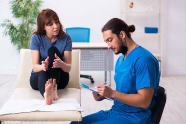 Erkek doktor travmatoloğu ziyaret eden yaralı bir kadın.