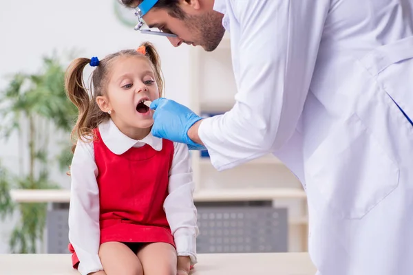 Petite fille visitant jeune médecin masculin otorhinolaryngologue — Photo