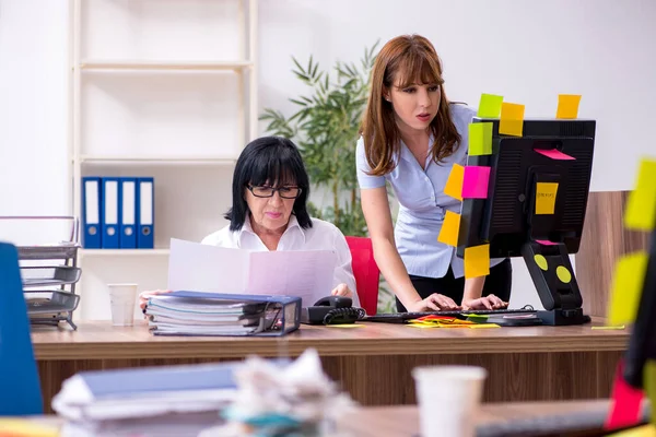 Dos empleadas y un trabajo excesivo en la oficina — Foto de Stock