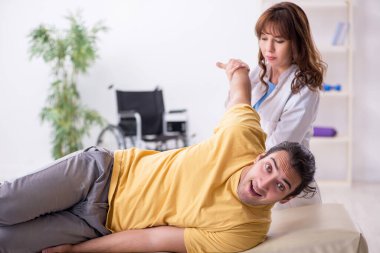 Yaralı adam genç bayan doktor osteopat 'ı ziyaret ediyor.