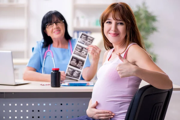 Jeune femme enceinte visite médecin gynécologue expérimenté — Photo