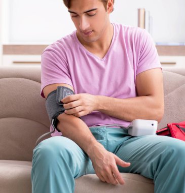 Evde ilk yardım çantasıyla hasta bir adam var.