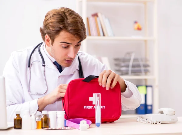 Young doctor with first aid kit in hospital — Stock Photo, Image