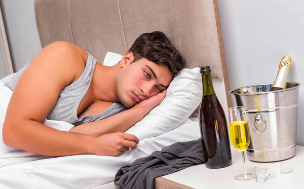 Человек в постели после вечеринки - концепция Hangover
