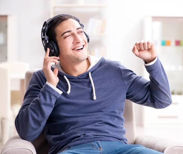 Jovem ouvindo música em casa — Fotografia de Stock