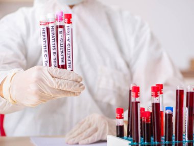 Genç yakışıklı laboratuvar asistanı hastanede kan örnekleri test ediyor.