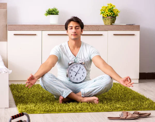 Fiatal férfi jógázik a hálószobában az időbeosztásban — Stock Fotó