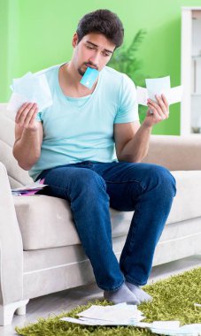 Genç adam kişisel finans ve faturalarla boğuşuyor.