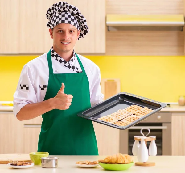 Mladý muž kuchař připravuje dort v kuchyni doma — Stock fotografie