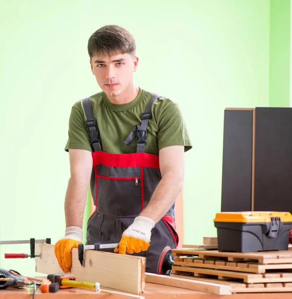 Jovem carpinteiro trabalhando em oficina — Fotografia de Stock