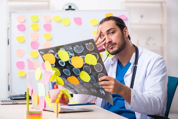 Jeune homme médecin dans un concept de priorités conflictuelles — Photo