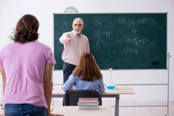 Starý učitel chemie a dva studenti ve třídě — Stock fotografie