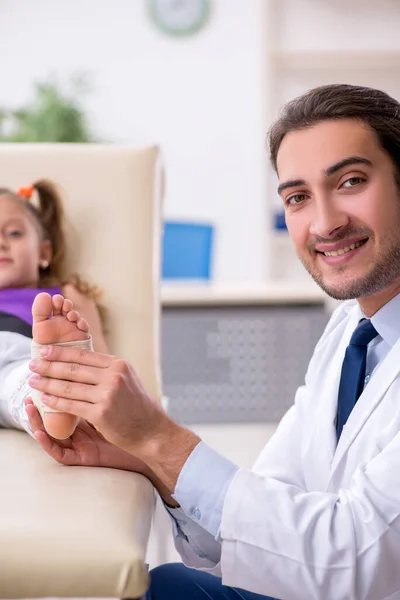 Menina pequena visitando jovem médico masculino — Fotografia de Stock