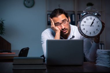 Gece ofiste çalışan genç bir erkek.