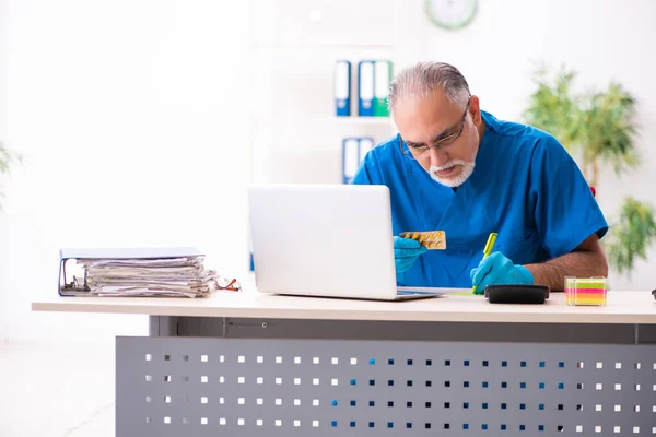 Viejo médico farmacéutico que trabaja en la clínica — Foto de Stock