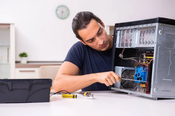 Junger Mann repariert Computer zu Hause — Stockfoto