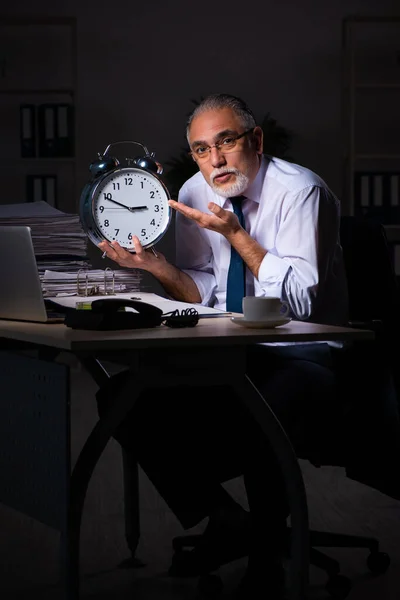 Old male employee working late at workplace — Stock Photo, Image