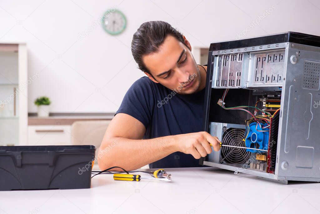 Young man repairing computer at home