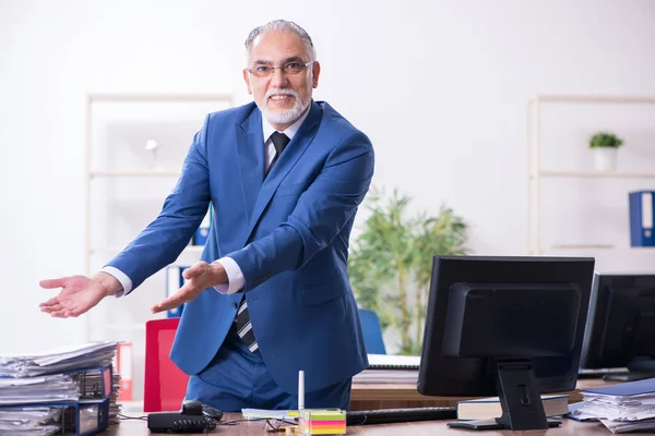 Velho empregado masculino e excesso de trabalho no escritório — Fotografia de Stock