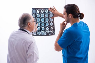 Klinikte çalışan iki erkek doktor.