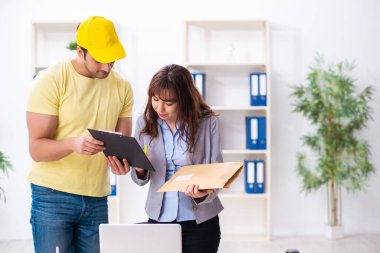 Genç erkek kurye ofise paket getiriyor.