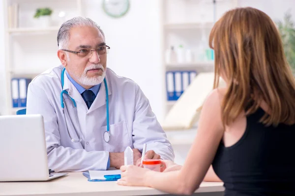 Genç kadın yaşlı erkek doktoru ziyaret ediyor. — Stok fotoğraf