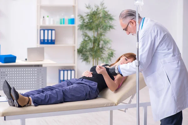 Giovane donna in visita vecchio medico maschio — Foto Stock