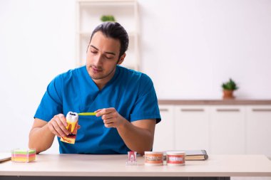 Klinikte çalışan genç erkek dişçi.