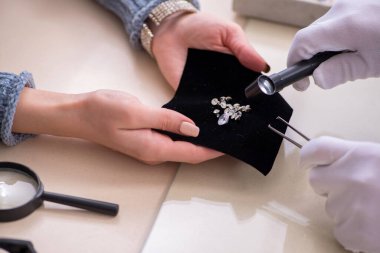 Mağazada erkek kuyumcu ve bayan müşteri