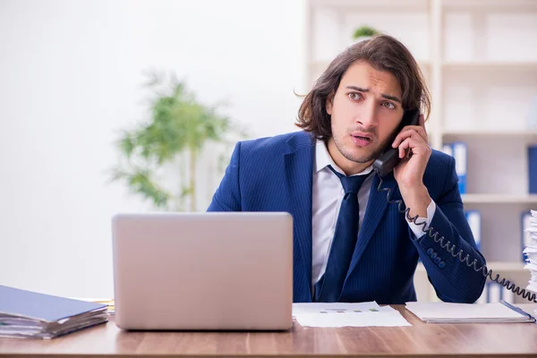 Jeune employé masculin malheureux avec un travail excessif — Photo