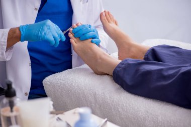 Podiatrist treating feet during procedure clipart