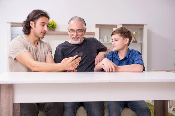 Abuelo aprendiendo nueva tecnología de hijo y nieto — Foto de Stock