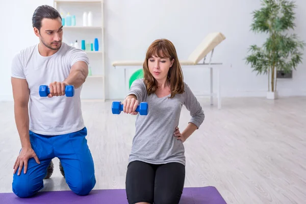 Kişisel koçla spor egzersizleri yapan genç bir kadın.