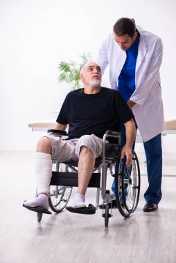 Yaşlı adam genç doktor travmatoloğu ziyaret ediyor.