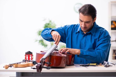 Genç erkek çello tamircisi.