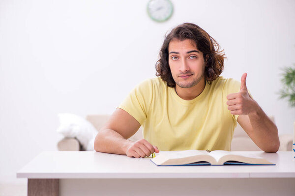 Young male student preparing for exams at home