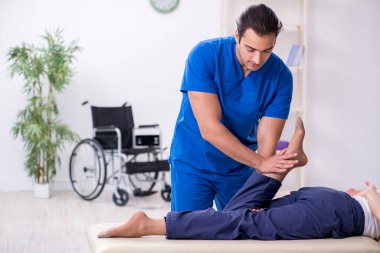 Yaralı kadın genç erkek doktor osteopat 'ı ziyaret ediyor.