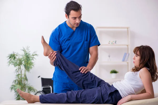 Mujer lesionada visitando al joven médico osteópata — Foto de Stock