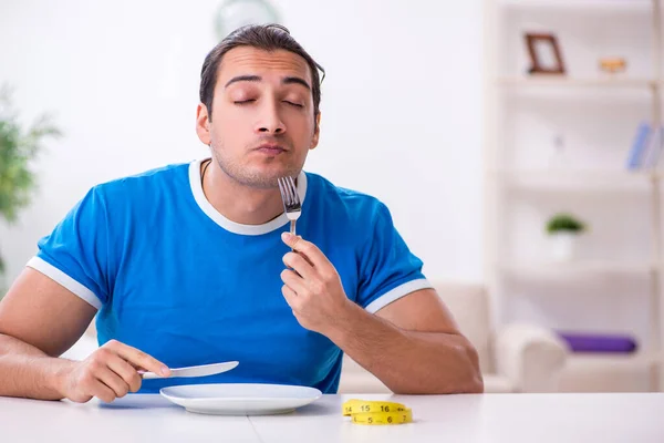 Giovane uomo affamato nel concetto di dieta — Foto Stock