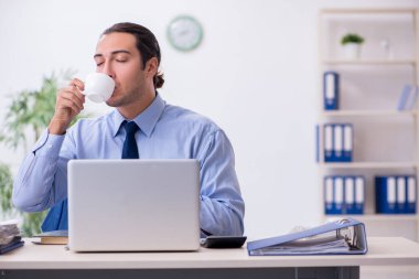 Ofiste genç bir erkek çalışan var.