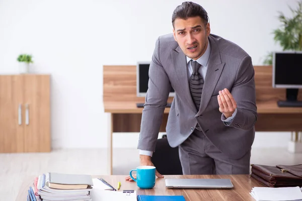 Giovane dipendente maschio infelice con il lavoro eccessivo — Foto Stock