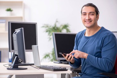 Ofiste çalışan genç bir erkek.