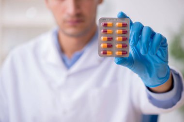 Uyuşturucu sentezi konseptinde genç erkek laboratuvar asistanı