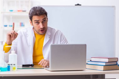 Genç erkek kimyager sınava hazırlanıyor.