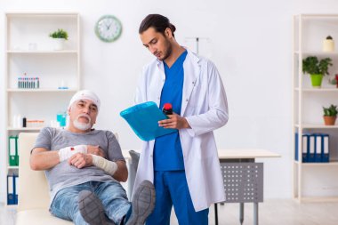 İlk yardım konseptinde genç erkek doktor ve yaşlı hasta.