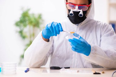 Erkek kriminolog kanıt için laboratuarda çalışıyor.