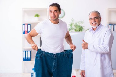 Doctor dietician and happy patient wearing large trousers