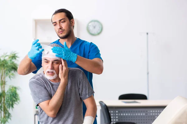 İlk yardım konseptinde genç erkek doktor ve yaşlı hasta. — Stok fotoğraf