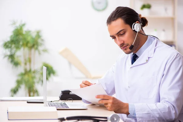 Joven médico escuchando al paciente durante la sesión de telemedicina — Foto de Stock